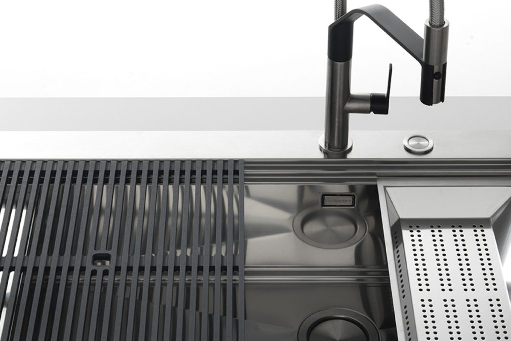 Foster kitchen sink with a dark mixer and coordinated preparation accessories.