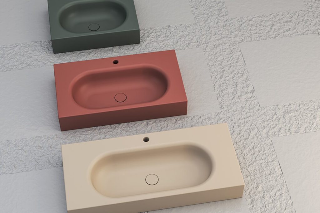 SDR Ceramiche washbasins in muted green, terracotta and cream.