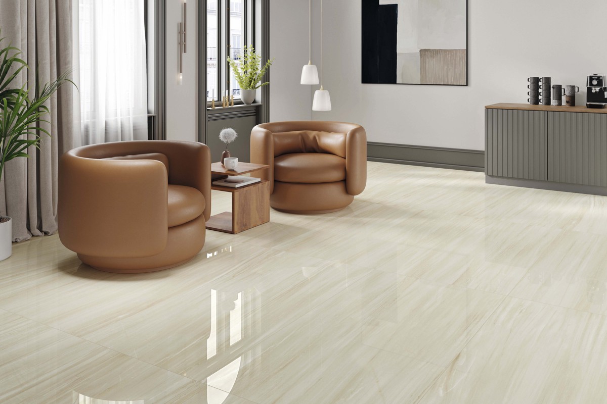 STN Cerámica Haldus Cream living room with a pale polished floor and tan chairs.