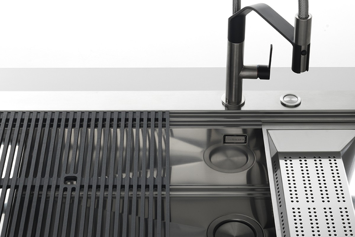 Foster kitchen sink with a dark mixer and coordinated preparation accessories.